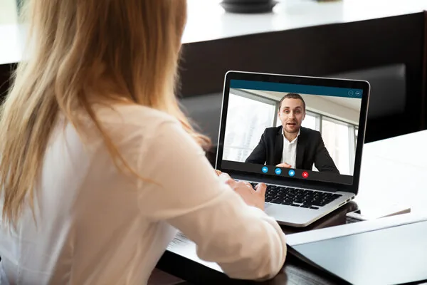 A guest at home joining an online speed dating night on her laptop